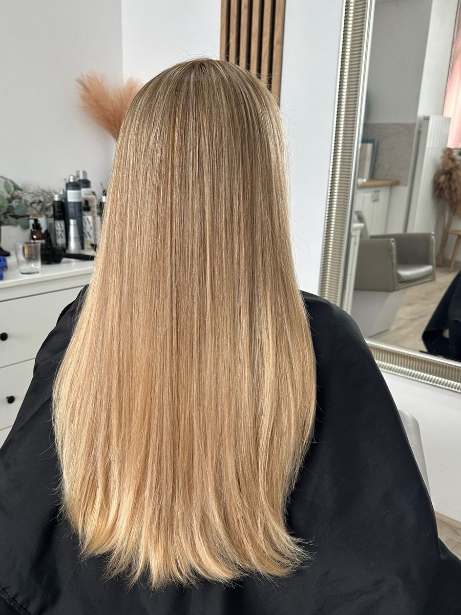 Dlhé medovo blond vlasy zozadu v salóne